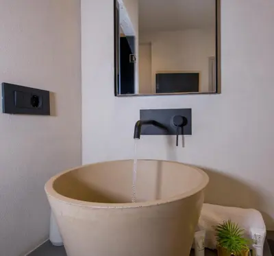 a bath tub with water running from a faucet in a bathroom at Cretan Berry Sarpaki in Chania Town