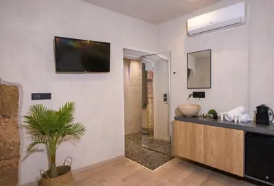 a bathroom with a sink and a television on a wall at Cretan Berry Sarpaki in Chania Town