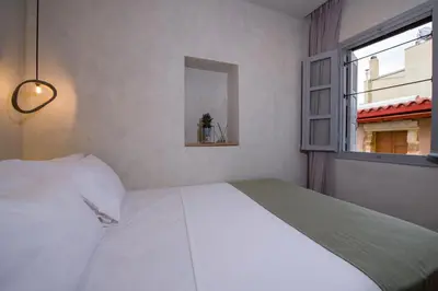 a bedroom with a large white bed and a window at Cretan Berry Sarpaki in Chania Town