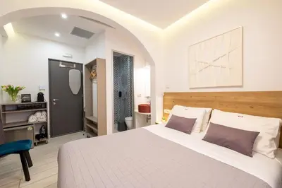 a bedroom with a white bed and a blue chair at Cretan Berry Portou in Chania Town
