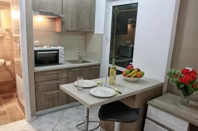a kitchen with a table with a bowl of fruit on it at Marias Studios in Chania Town