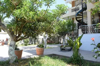 a courtyard with trees and a building at Modern Apartment with Garden in Kissamos