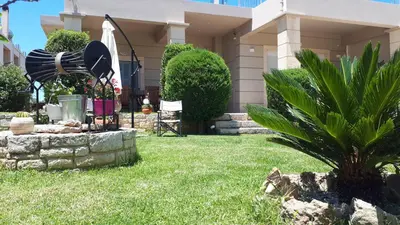a house with a yard with a fountain in the grass at Modern Villa in Chania in Perivólia