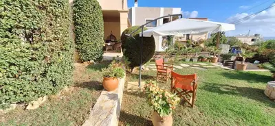a patio with two chairs and an umbrella at Modern Villa in Chania in Perivólia