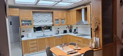 a kitchen with wooden cabinets and a table and a sink at Modern Villa in Chania in Perivólia