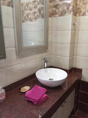 a bathroom sink with a purple towel on a counter at 