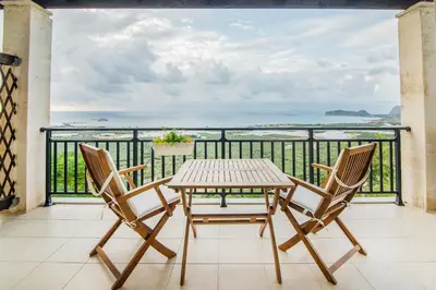 a table and chairs on a balcony with a view at Roubini Apartments in Falasarna