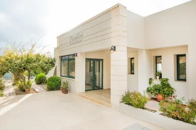 a white building with plants in front of it at Roubini Apartments in Falasarna