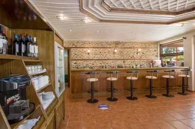 a bar with stools in the middle of a room at Omega Platanias in Plataniás
