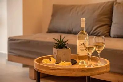 a bottle of wine and two glasses on a table at Omega Platanias in Plataniás