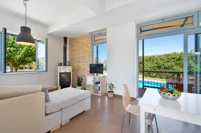 a living room with a couch and a table at Calma Seaside Villa in Kalyves