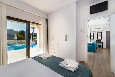 a bedroom with a bed and a view of a pool at Platanias Villa Mirsini in Plataniás