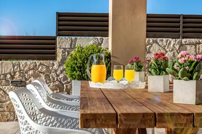 a wooden table with two glasses of orange juice at Platanias Villa Mirsini in Plataniás