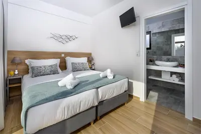a bedroom with a large bed and a bathroom at Platanias Villa Mirsini in Plataniás