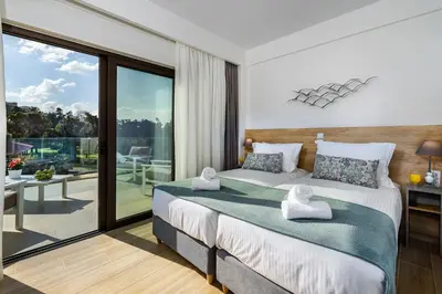 a bedroom with a large bed and a balcony at Platanias Villa Mirsini in Plataniás