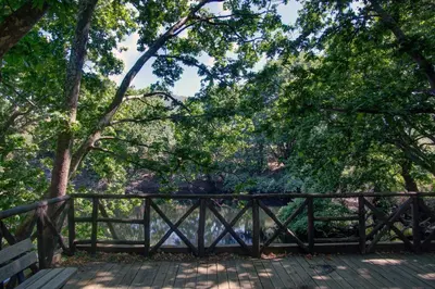 a wooden bridge with a bench and trees at Antartisa B&B in Límni