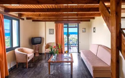 a living room with a couch and chairs and a tv at Antilia Apartments in Tavronitis