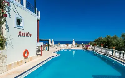 a swimming pool at a hotel with the ocean in the background at Antilia Apartments in Tavronitis