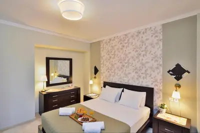 a bedroom with a bed with a tray of food on it at Poseidon Apartments in Kato Daratso