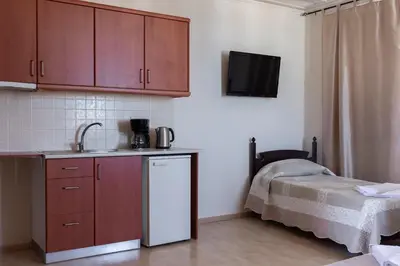 a kitchen with a sink and a refrigerator and a bed at Narkissos 'SUPERB' in Chania Town