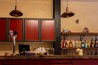 a kitchen with red cabinets and a counter with alcohol at Narkissos 'SUPERB' in Chania Town
