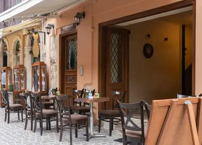 a restaurant with tables and chairs and a clock on the wall at Narkissos 'SUPERB' in Chania Town