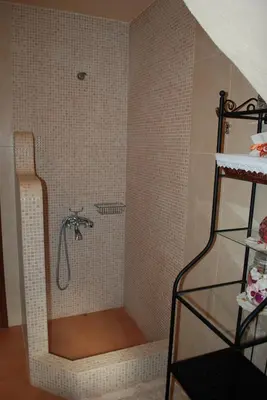 a shower in a bathroom with a tiled wall at Drys Villas in Xirokámbion