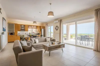 a living room with a couch and a table at NeSo - Peter's Flat steps to Beach with Great Views in Kolymvari