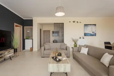 a living room with a couch and a table at NeSo - Peter's Flat steps to Beach with Great Views in Kolymvari