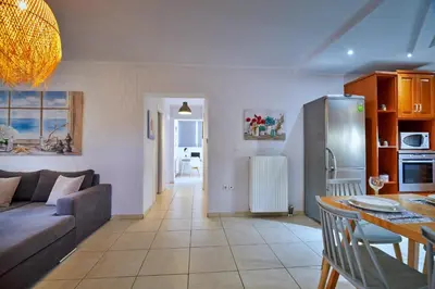 a kitchen and living room with a couch and a table at Sunny Luxury Apartment in Chania Town