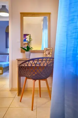 a table with a mirror and a chair in a room at Sunny Luxury Apartment in Chania Town