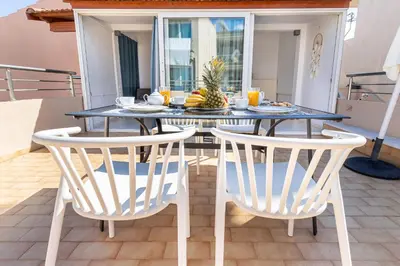 a dining table with two white chairs and a blue table at Sunny Luxury Apartment in Chania Town
