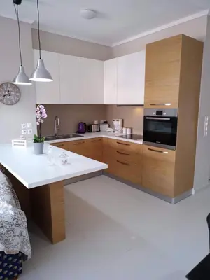 a kitchen with wooden cabinets and a white counter top at Konstantina Apartment near the Beach in Chania Town