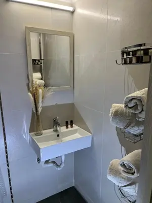 a bathroom with a sink and a mirror and towels at Konstantina Apartment near the Beach in Chania Town