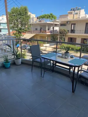 a patio with a table and chairs on a balcony at Konstantina Apartment near the Beach in Chania Town