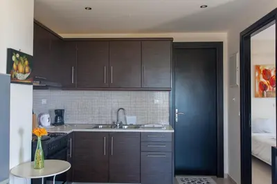 a kitchen with dark wood cabinets and a sink at Paleochora Houses N2 in Palaiochóra