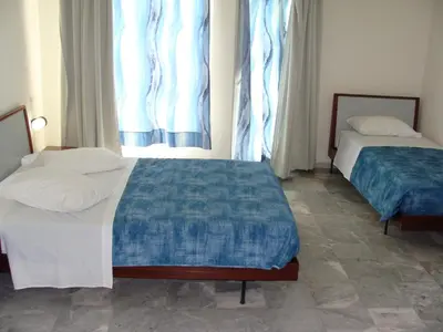 two beds in a room with two windows at Rodon Hotel in Chania Town