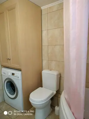 a bathroom with a toilet and a washing machine at Chrisas Apartment Chania in Chania Town