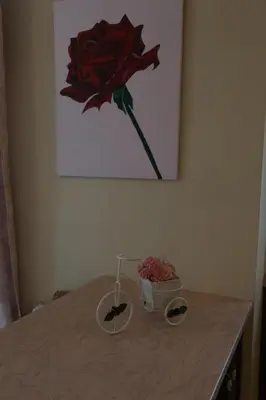 a table with a flower in a painting and a bowl of flowers at Chrisas Apartment Chania in Chania Town