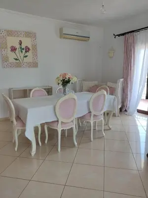 a white dining room table with pink chairs and a table at Chrisas Apartment Chania in Chania Town