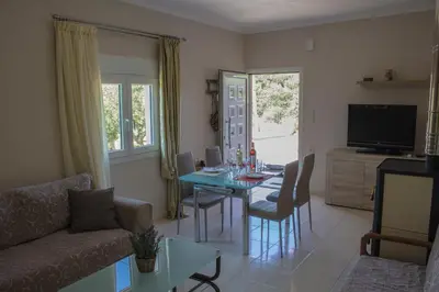 a living room with a table and a couch at Lydia's Apartment in Stílos