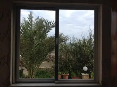 a window with a view of a palm tree at House with Sea View close to Platanias in Vrísai
