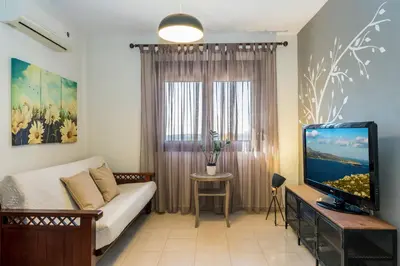 a living room with a couch and a television at Margarita Apt - Amazing Relaxing View in Megála Khoráfia