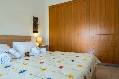 a bedroom with a large bed and a wooden cabinet at Margarita Apt - Amazing Relaxing View in Megála Khoráfia