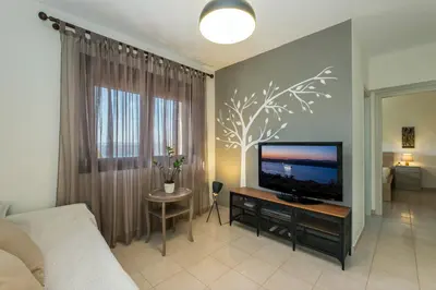 a bedroom with a flat screen tv in a room at Margarita Apt - Amazing Relaxing View in Megála Khoráfia
