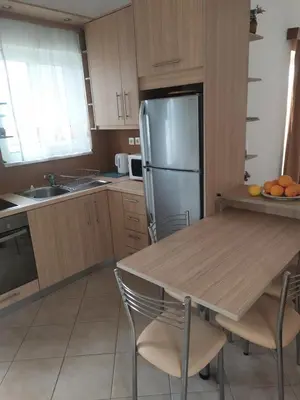a kitchen with a table and a stainless steel refrigerator at Panoramic Balos Sea View House in Kissamos