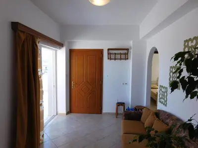 a living room with a couch and a wooden door at Panoramic Balos Sea View House in Kissamos