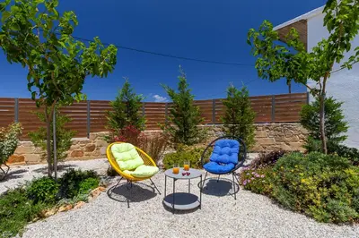 two chairs and a table in a garden at Trialonia Luxury Villa in Kissamos