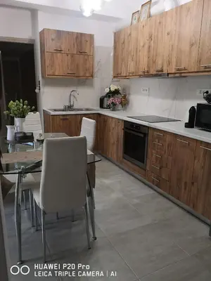 a kitchen with wooden cabinets and a table with chairs at A Pleasant Stay in Chania in Chania Town