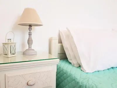a bedroom with a bed and a table with a lamp at Terra Falasarna in Falasarna